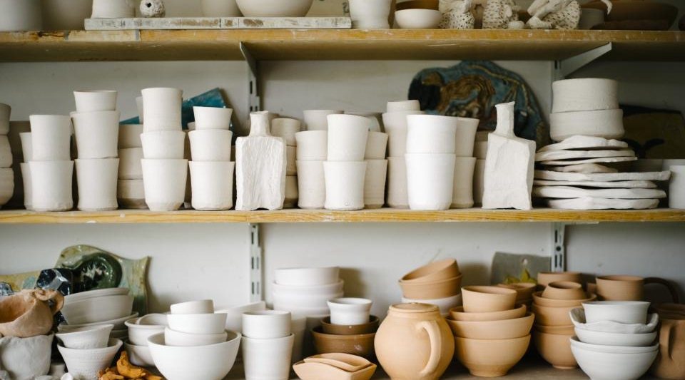 Hand-thrown stoneware drying on a workshop shelf