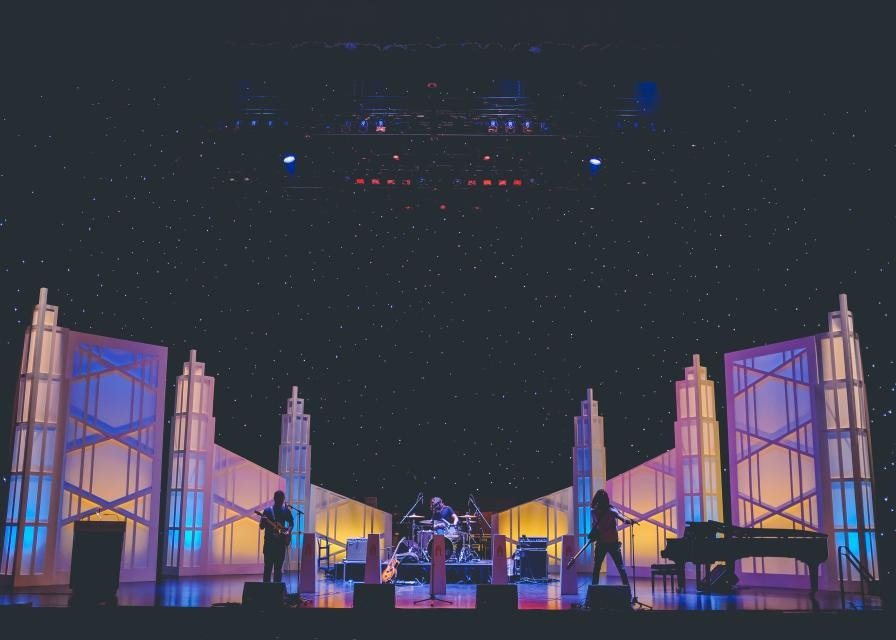 Coloured light beams cutting through haze inside the venue